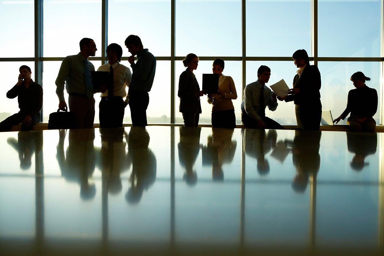 Business meeting in brightly lit glassed conference room