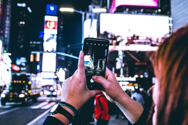Woman taking photo with cell phone in Times Square