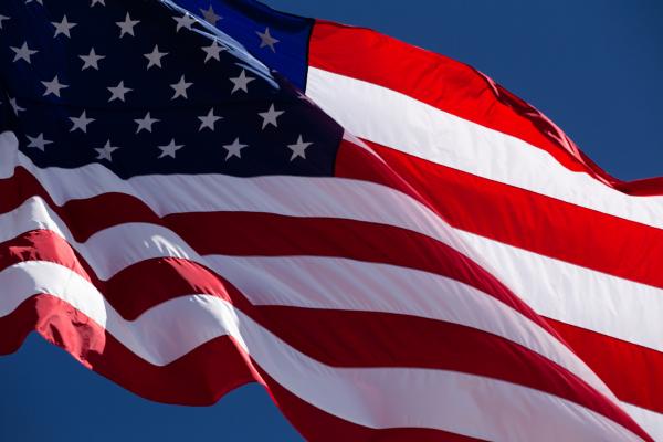 American Flag blowing in wind on blue sky