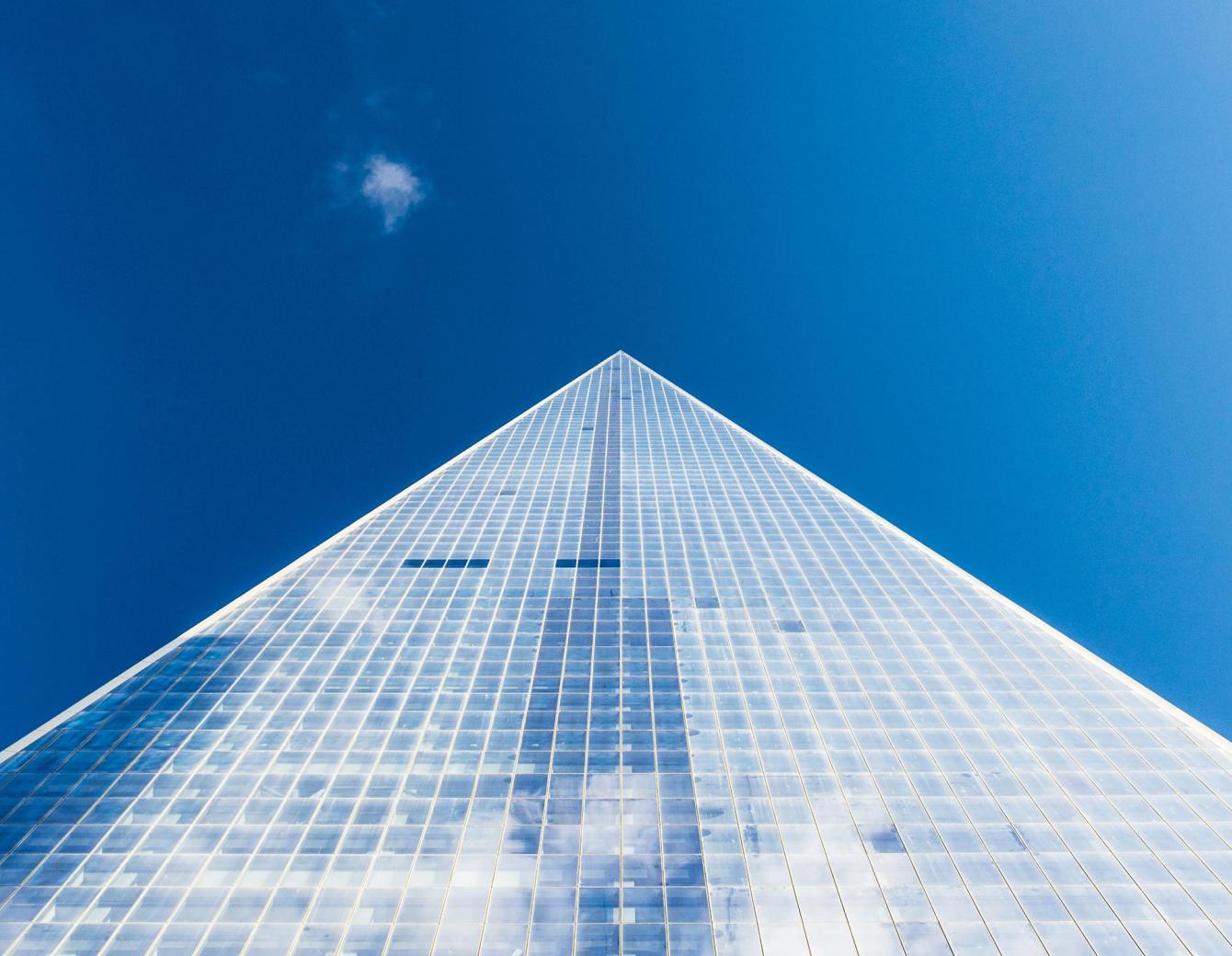 Looking up at a glass building and sky