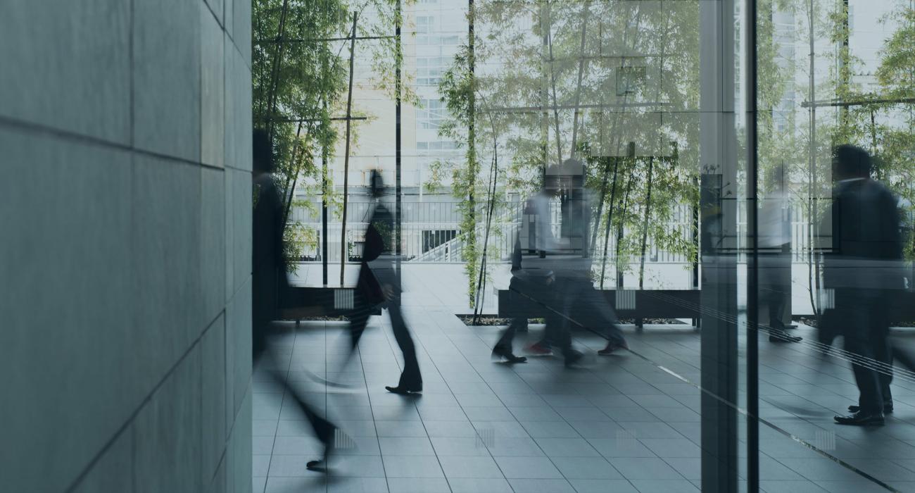 Blurry people walking in an office lobby