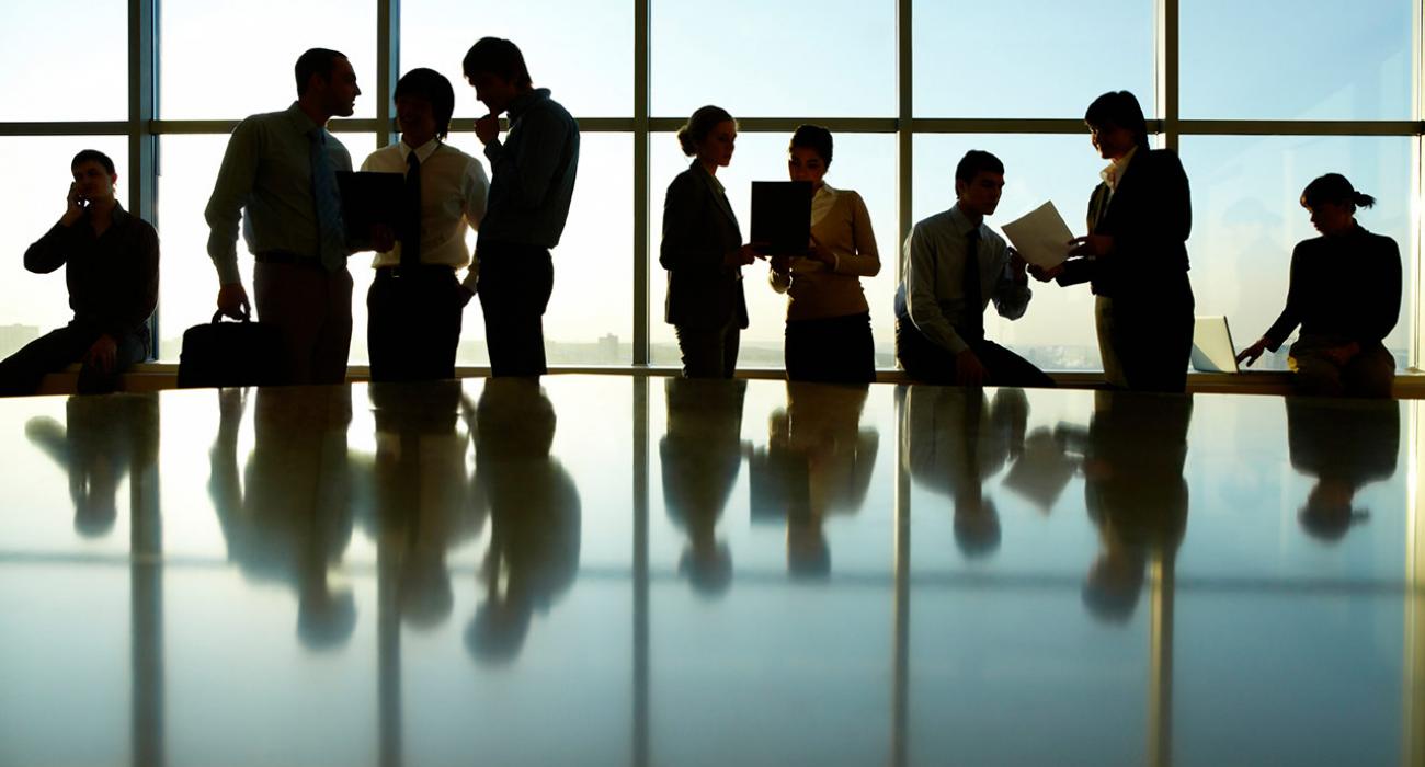 Business meeting in brightly lit glassed conference room