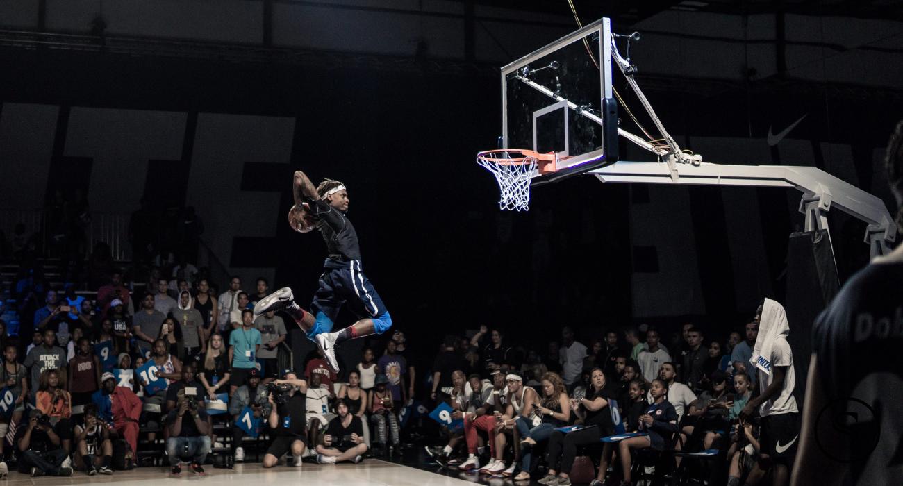 Man on open court, dunks while crowd watches