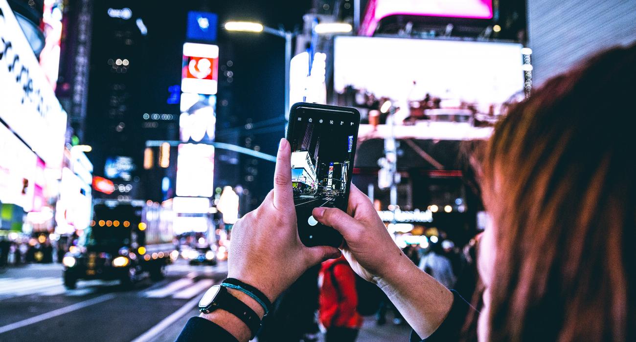 Woman taking photo with cell phone in Times Square