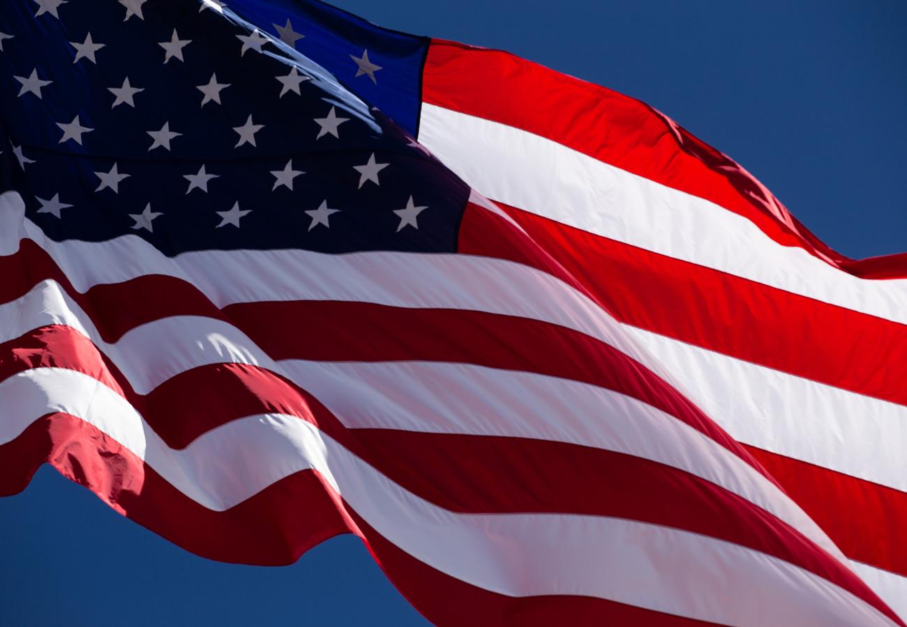 American Flag blowing in wind on blue sky